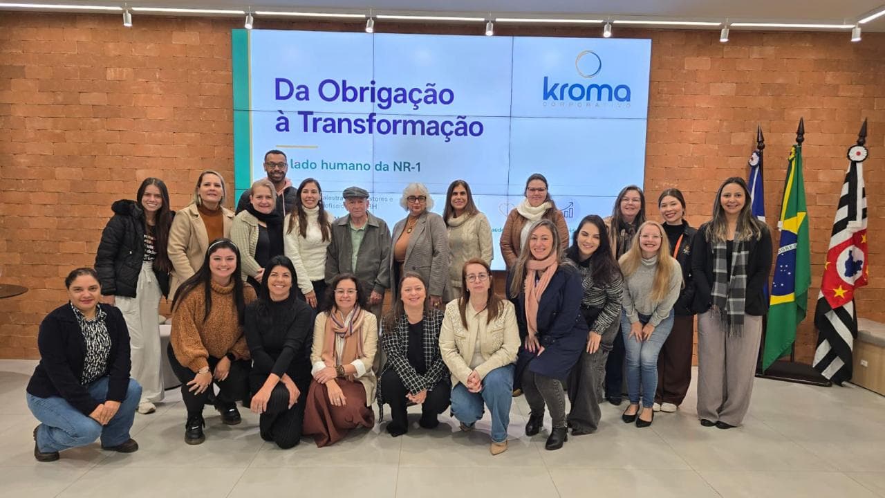 Palestra da Kroma Corporativa sobre o lado humano da NR-1, com a equipe reunida diante do telão